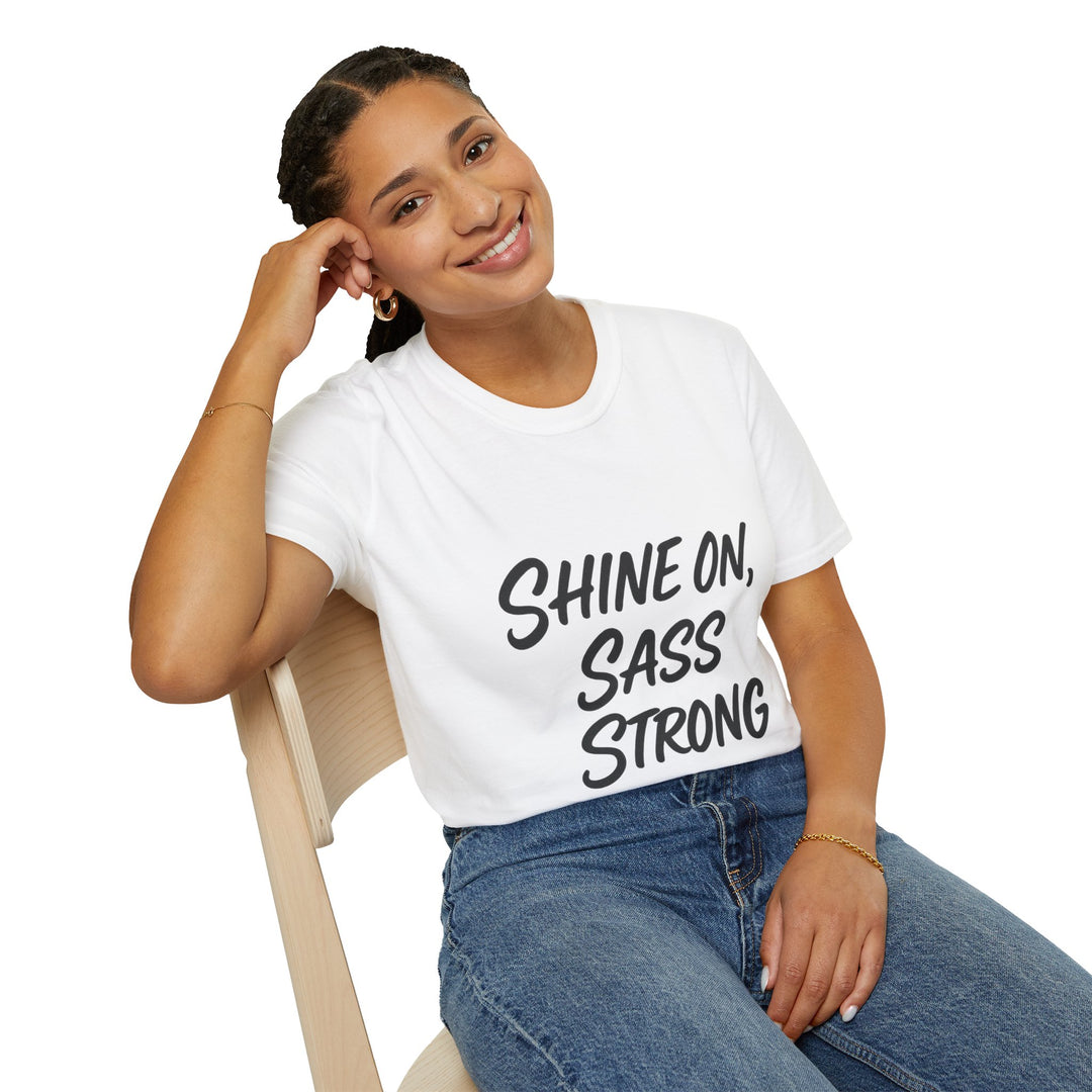 Female model wearing a white t-shirt with 'SHINE ON, SASS STRONG' text, sitting on a chair